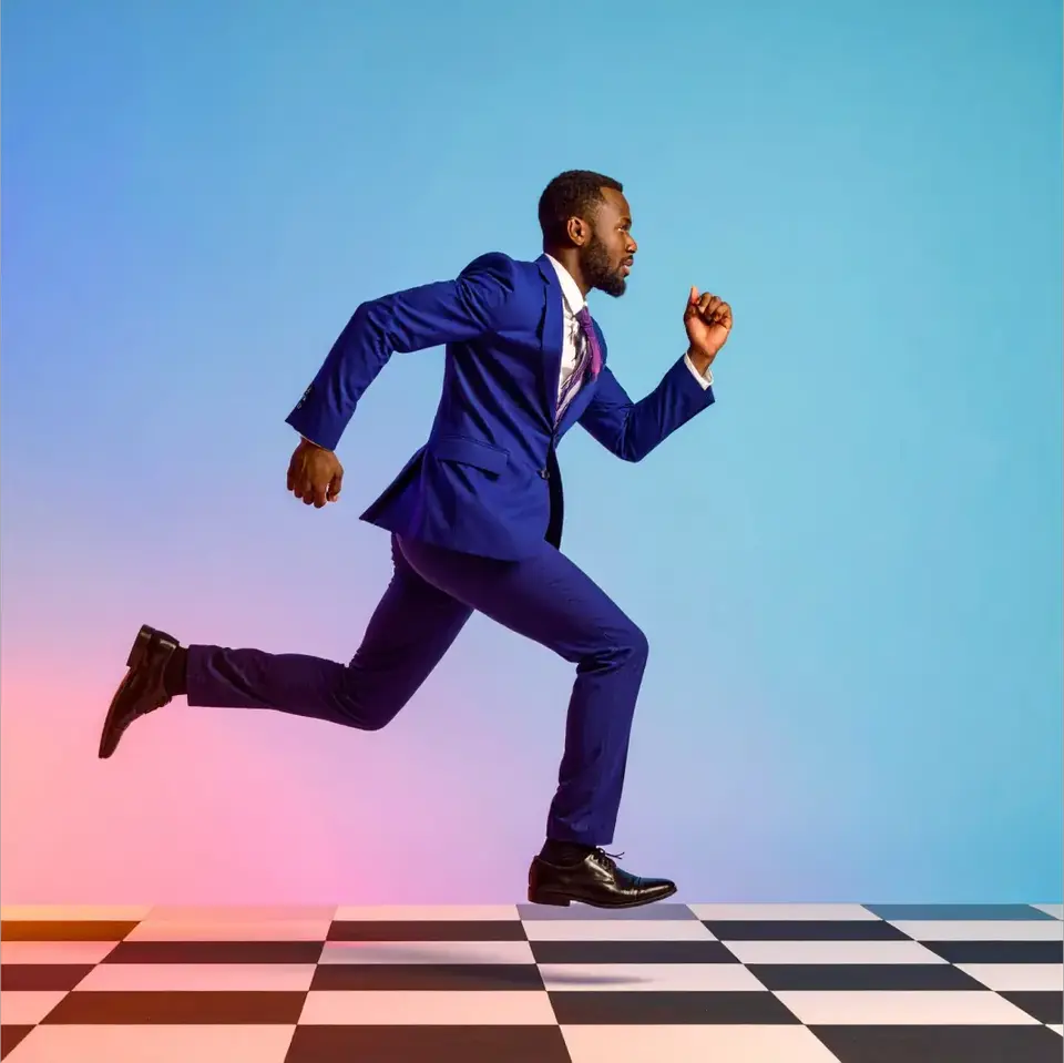 A man in a blue suit running energetically across a black-and-white checkered floor, against a vibrant gradient background of pink, purple, and blue.